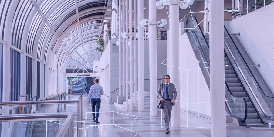 2 employees walking through large commercial office space