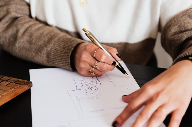 woman sketching real estate floor plan